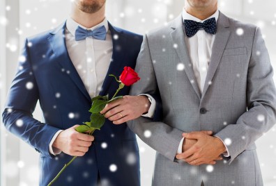 close up of happy male gay couple holding hands